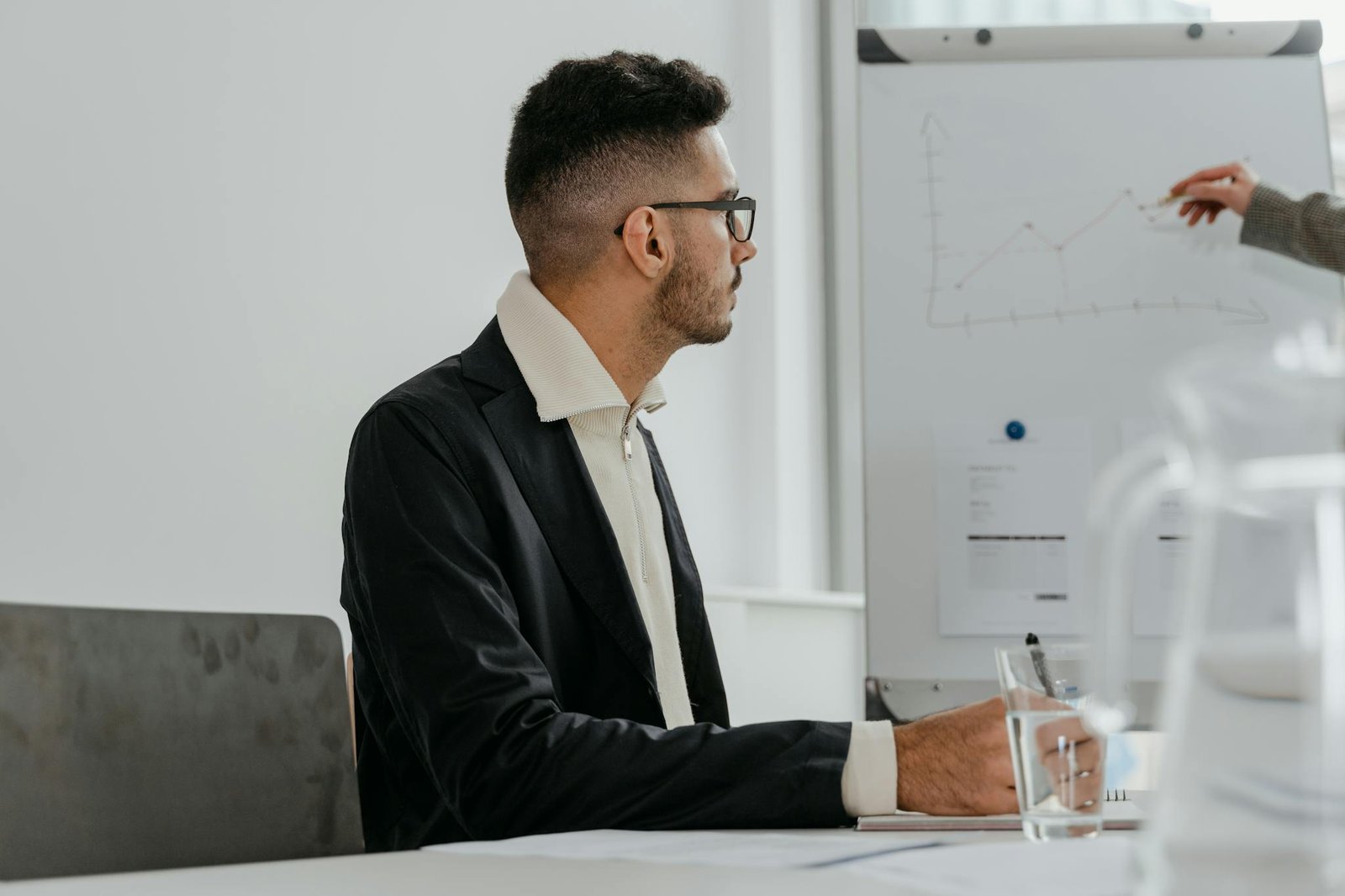À propos Professional male analyzing growth chart during modern office meeting session.